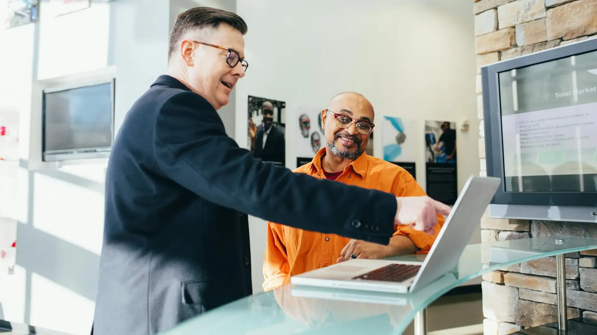 a man showing another man something on the screen he's excited about.